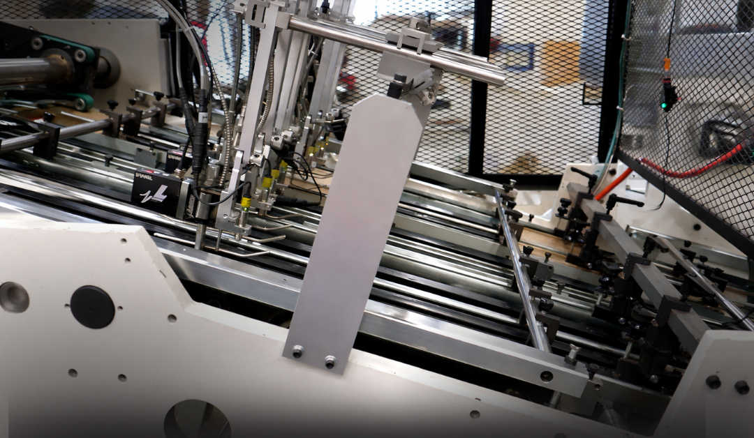 High-speed straight line forming machine with metal guide rails and pneumatic components inside an industrial manufacturing facility.